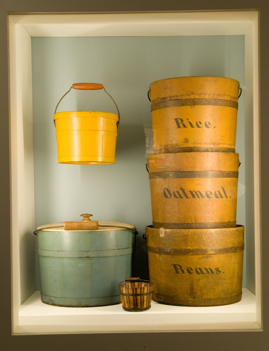 A display of tin buckets on a shelf.