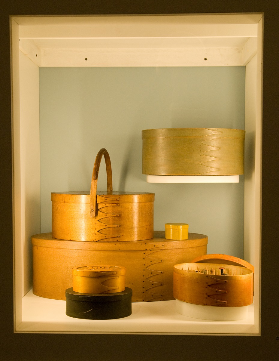 A display of wooden bowls in a glass case.