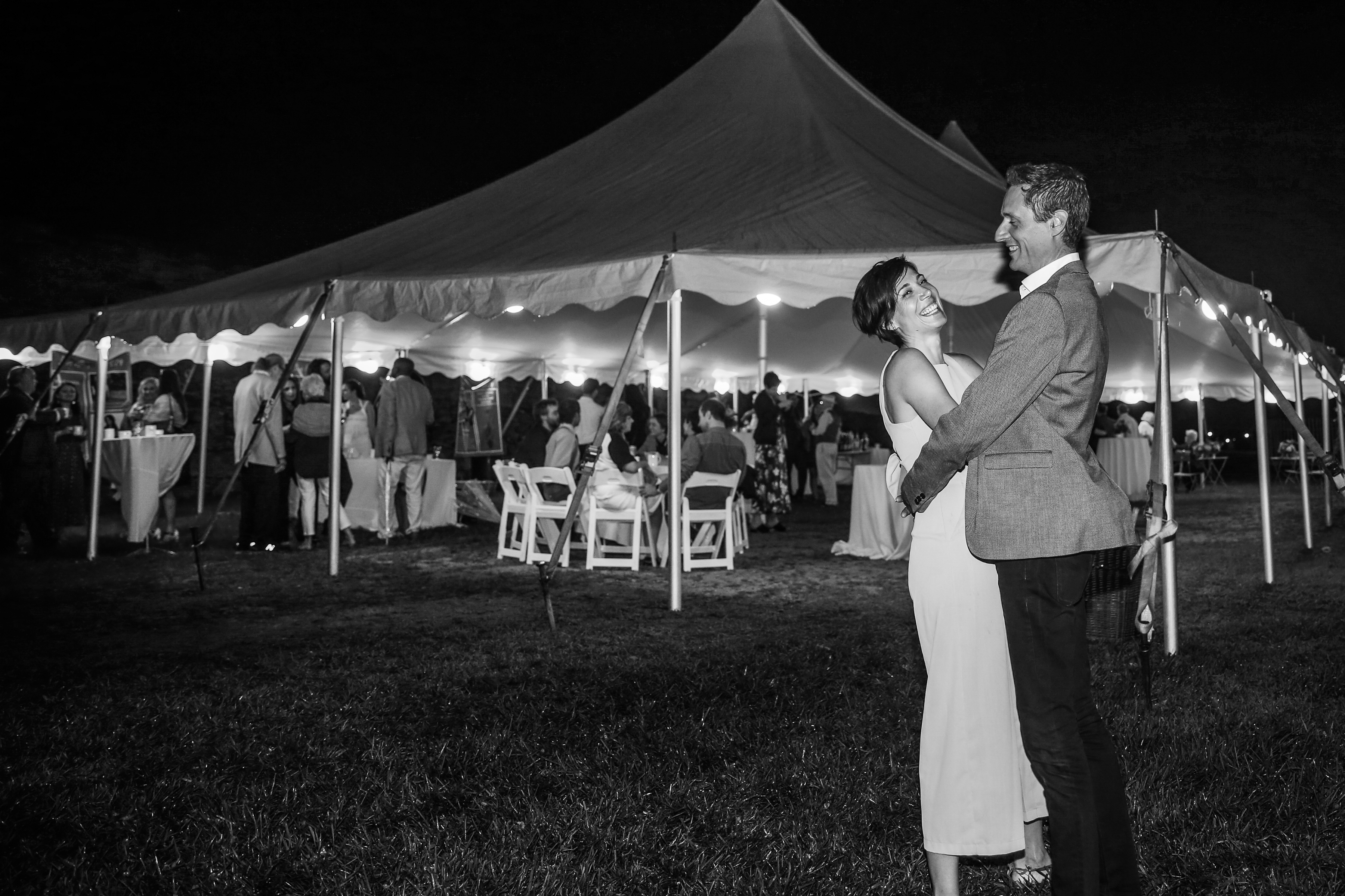 A bride and groom dancing under a tent.