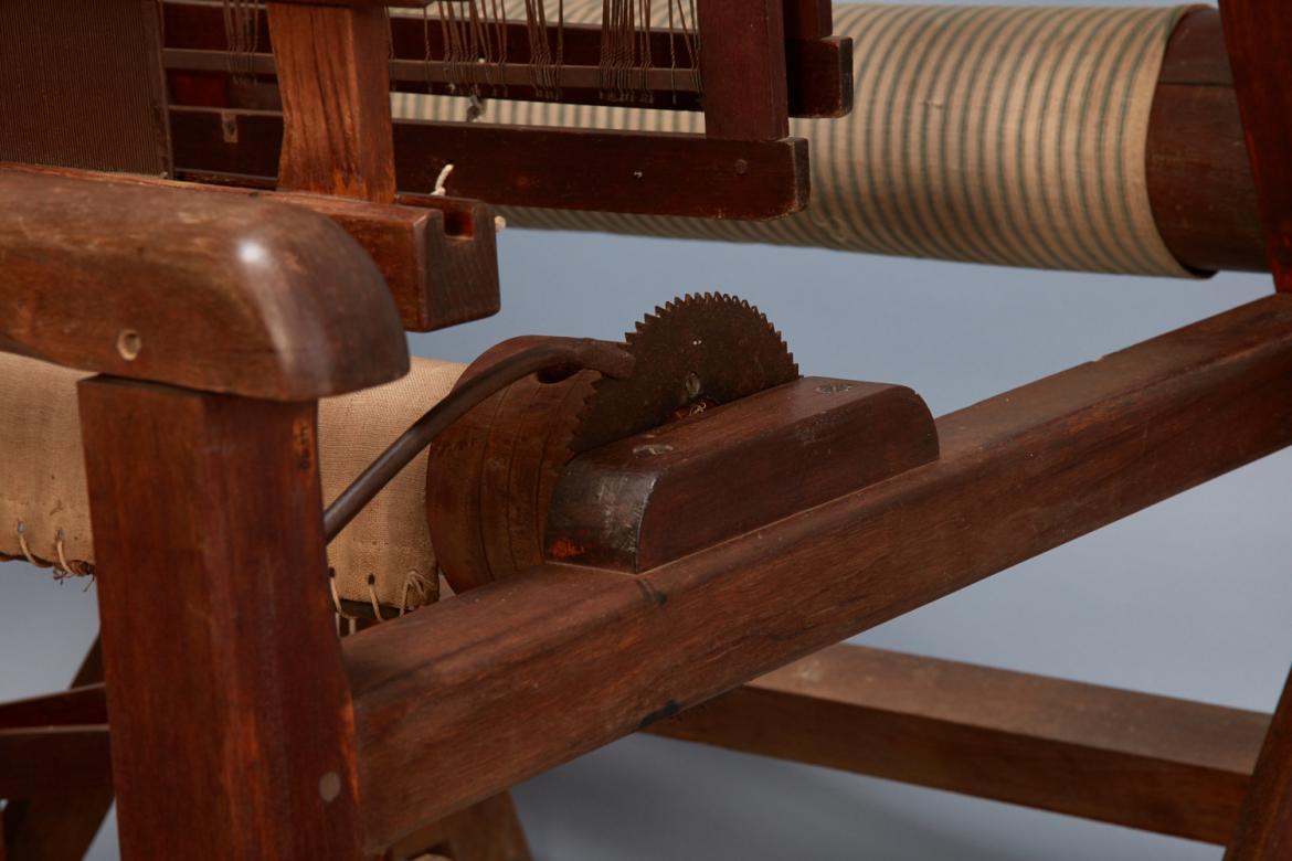 A wooden loom with a wooden handle.