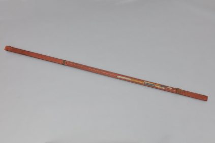 A wooden stick on a white surface.