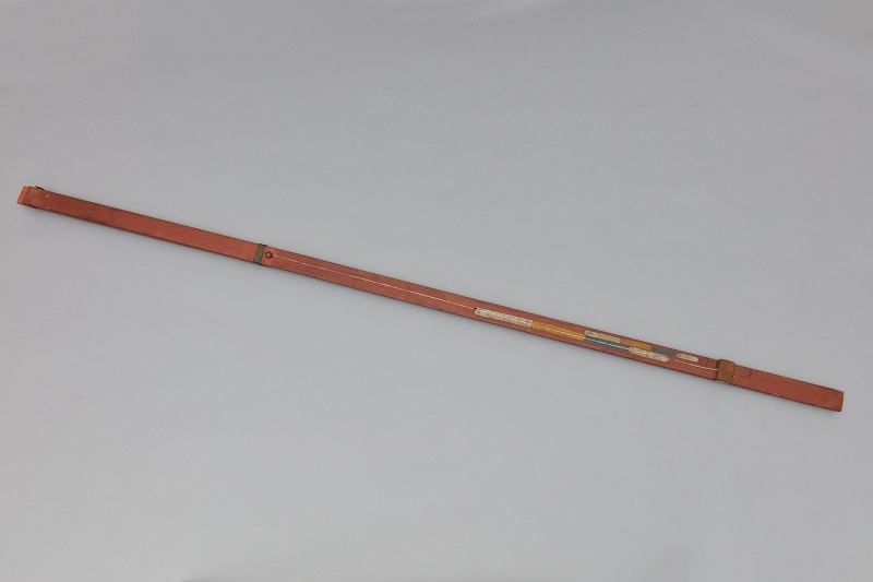 A wooden stick on a white surface.