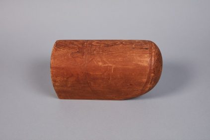 A wooden bowl sitting on a grey surface.