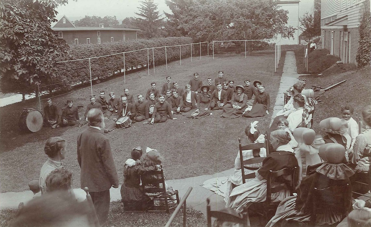 A group of people sitting on a lawn.