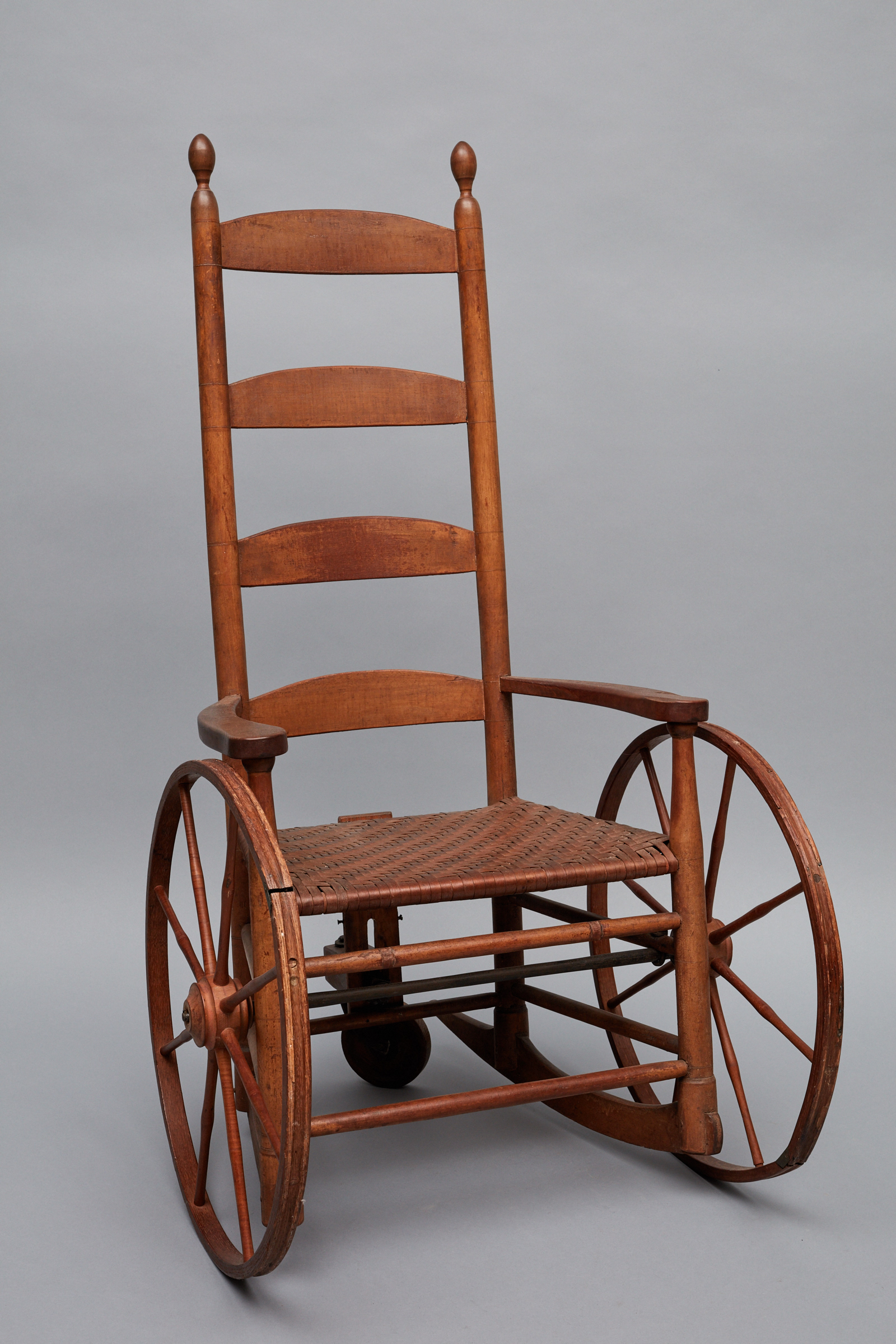 A wooden rocking chair on a gray background.