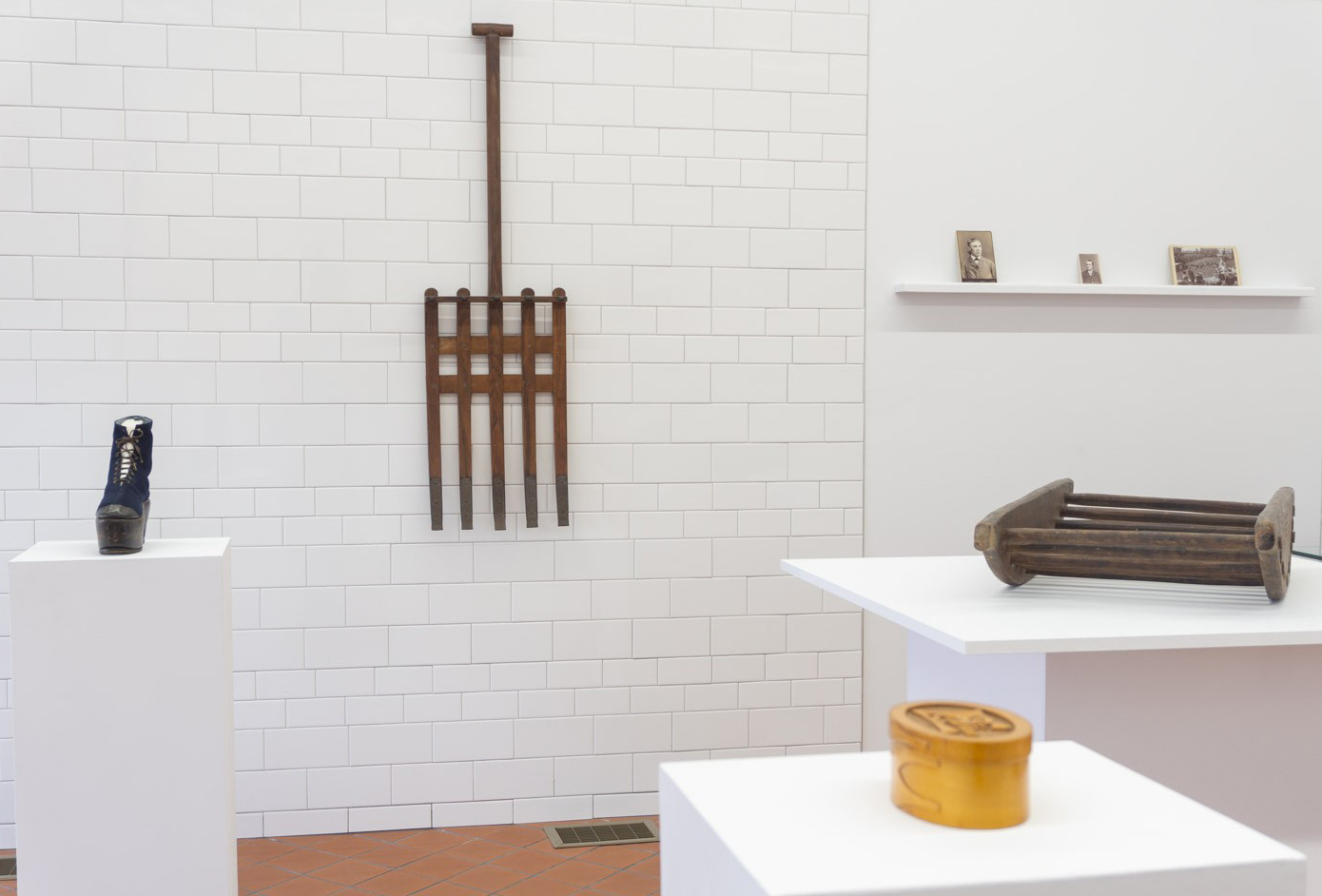 A room with a wooden rake and other items on display.