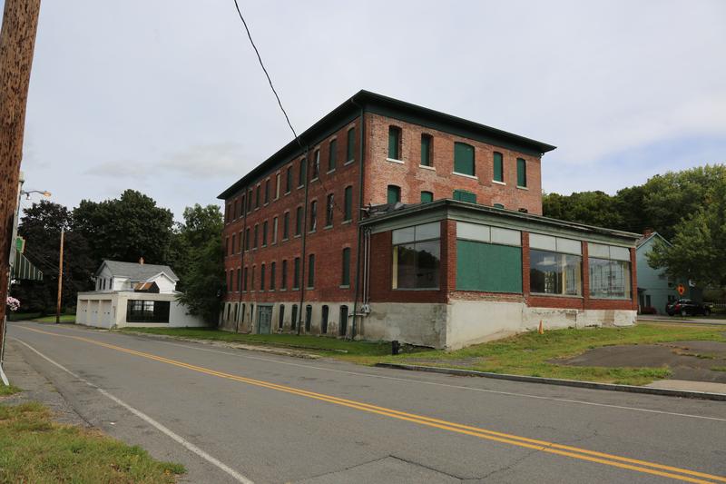 An old brick building sits on the side of the road.