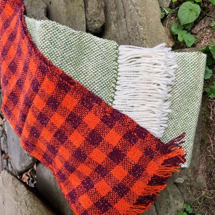 Two plaid blankets on a rock.