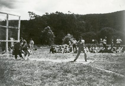 A group of people playing a game of baseball in a field.