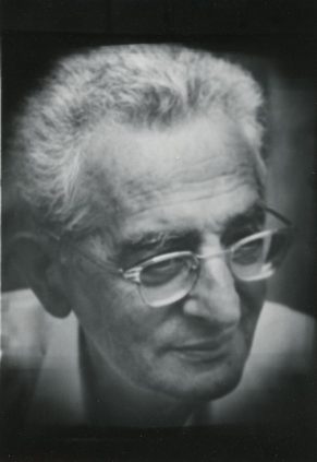 A black and white photo of a man with glasses.