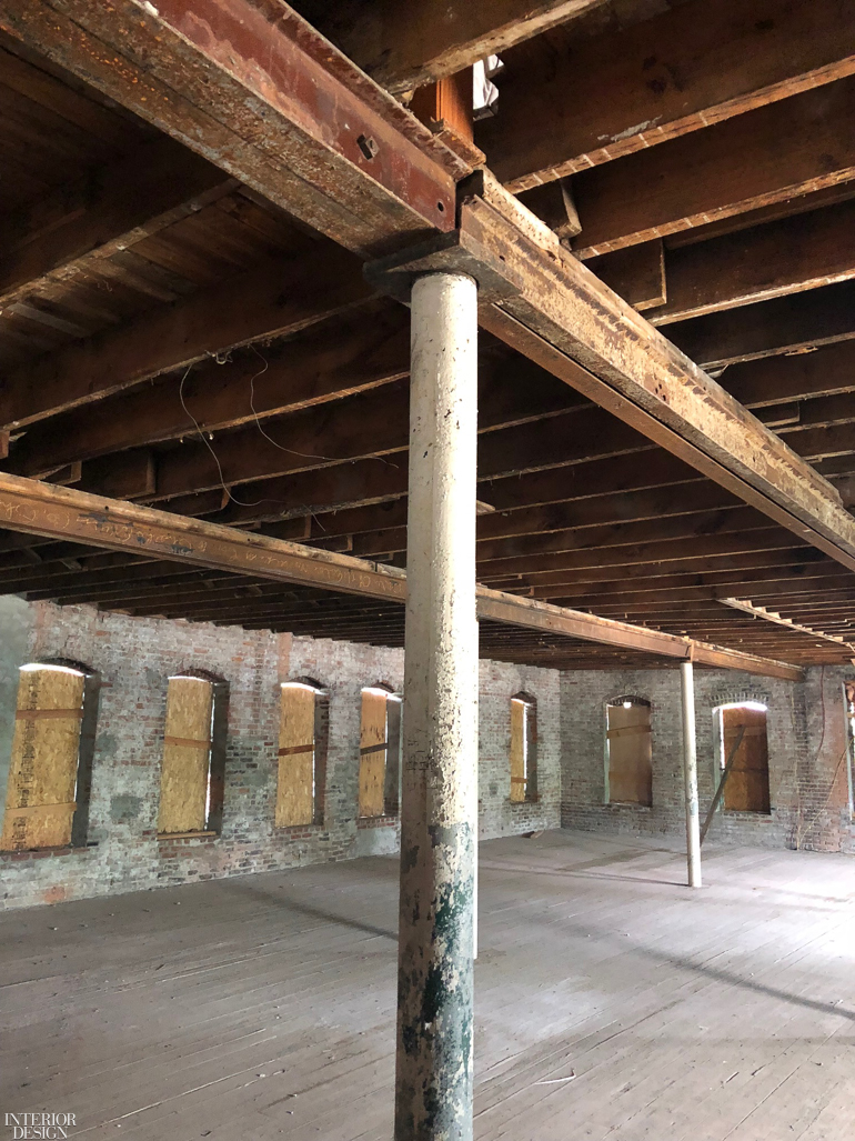 The inside of an old building with columns and beams.