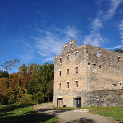 A stone building in the middle of a field.