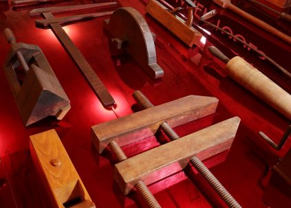 Various woodworking tools are displayed on a red table.