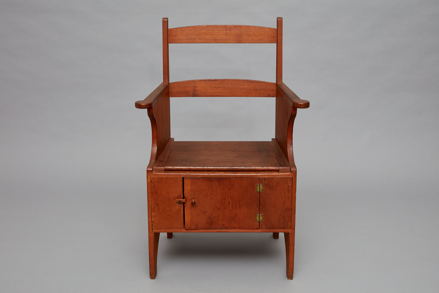 A wooden chair with a wooden seat and a drawer.