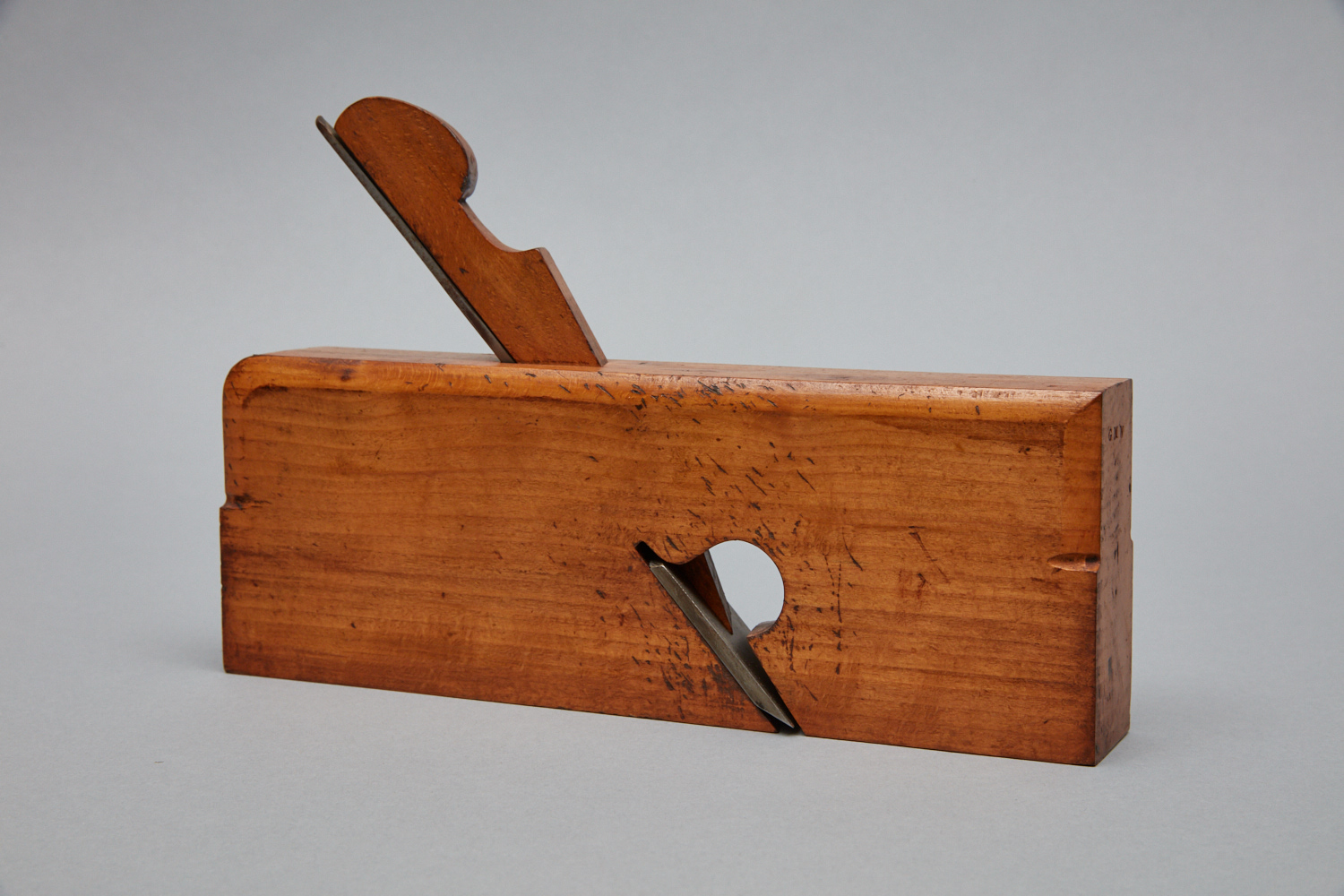 A wooden box with a knife in it.