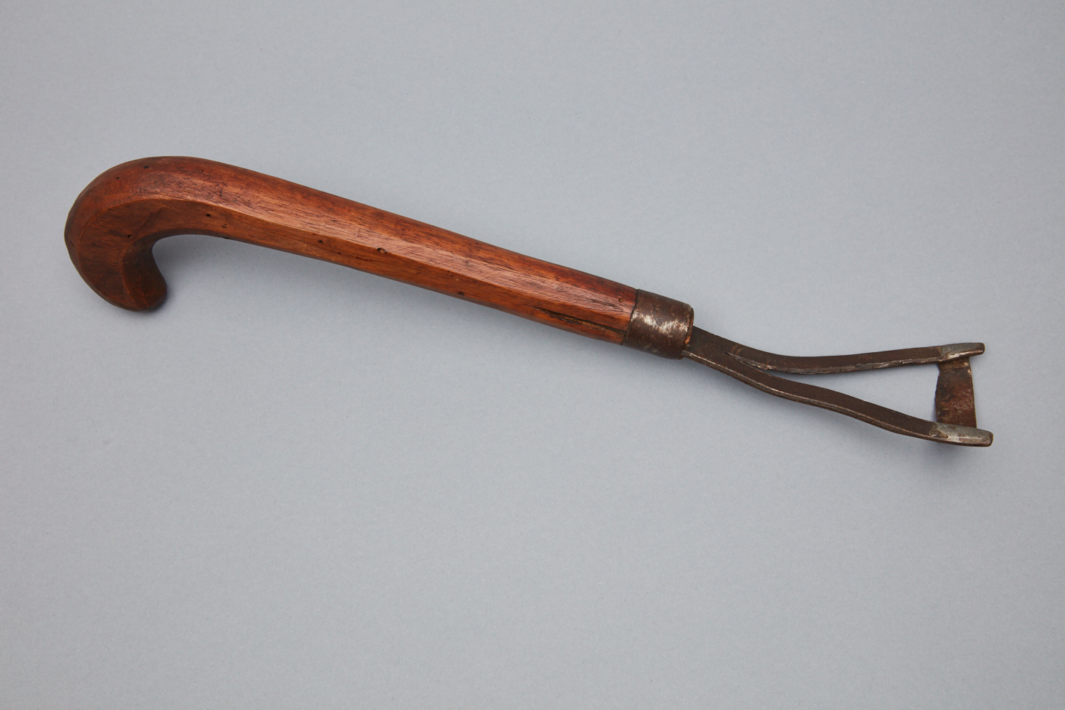 A wooden cane with a wooden handle.