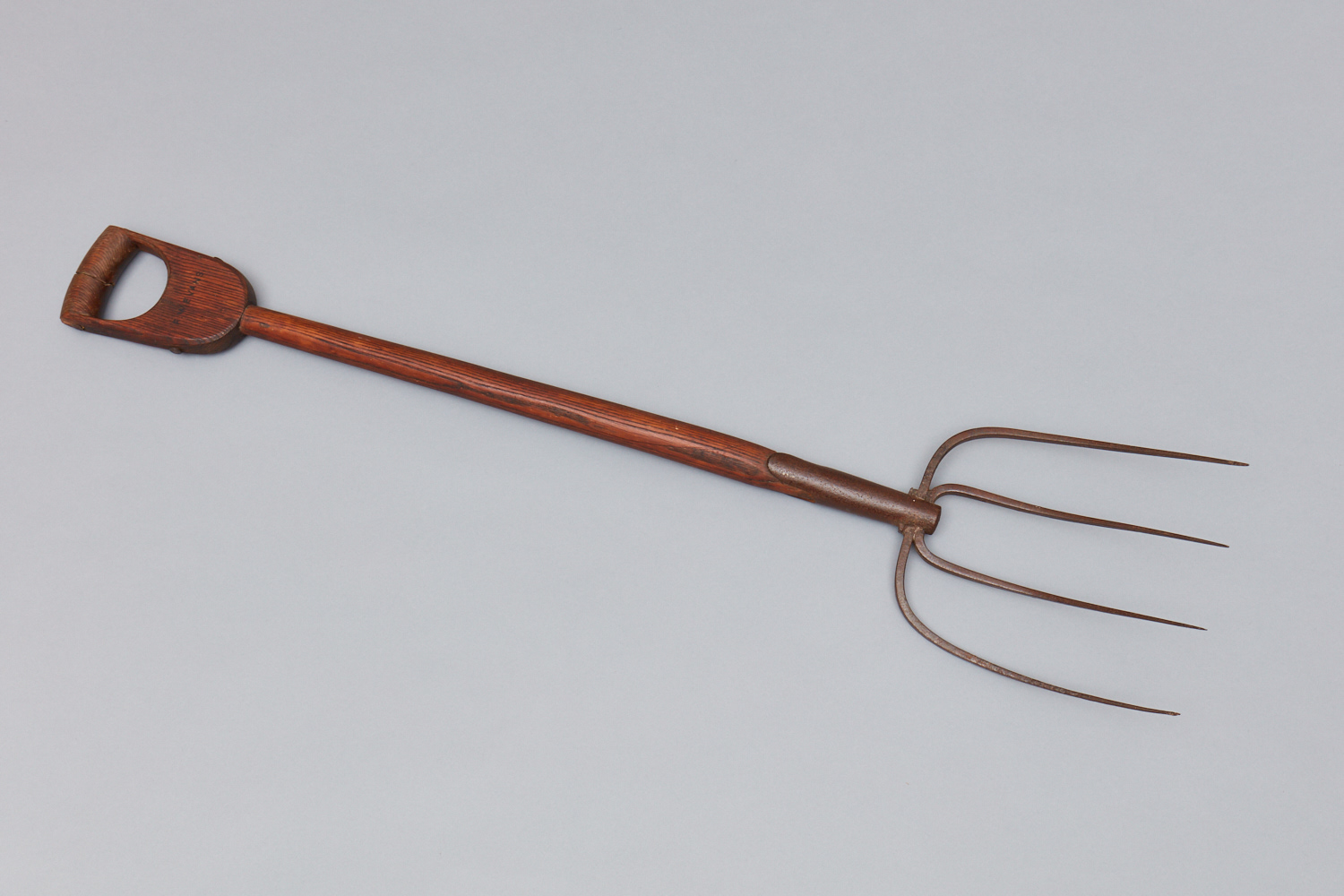 A garden fork with a wooden handle.