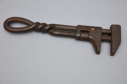An old iron pliers on a gray surface.