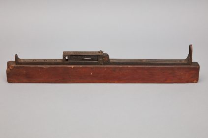 A wooden planer on top of a piece of wood.
