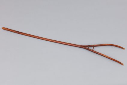 A wooden rake with a wooden handle.