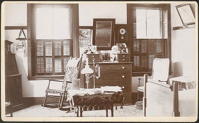 An old photo of a bedroom with a dresser.