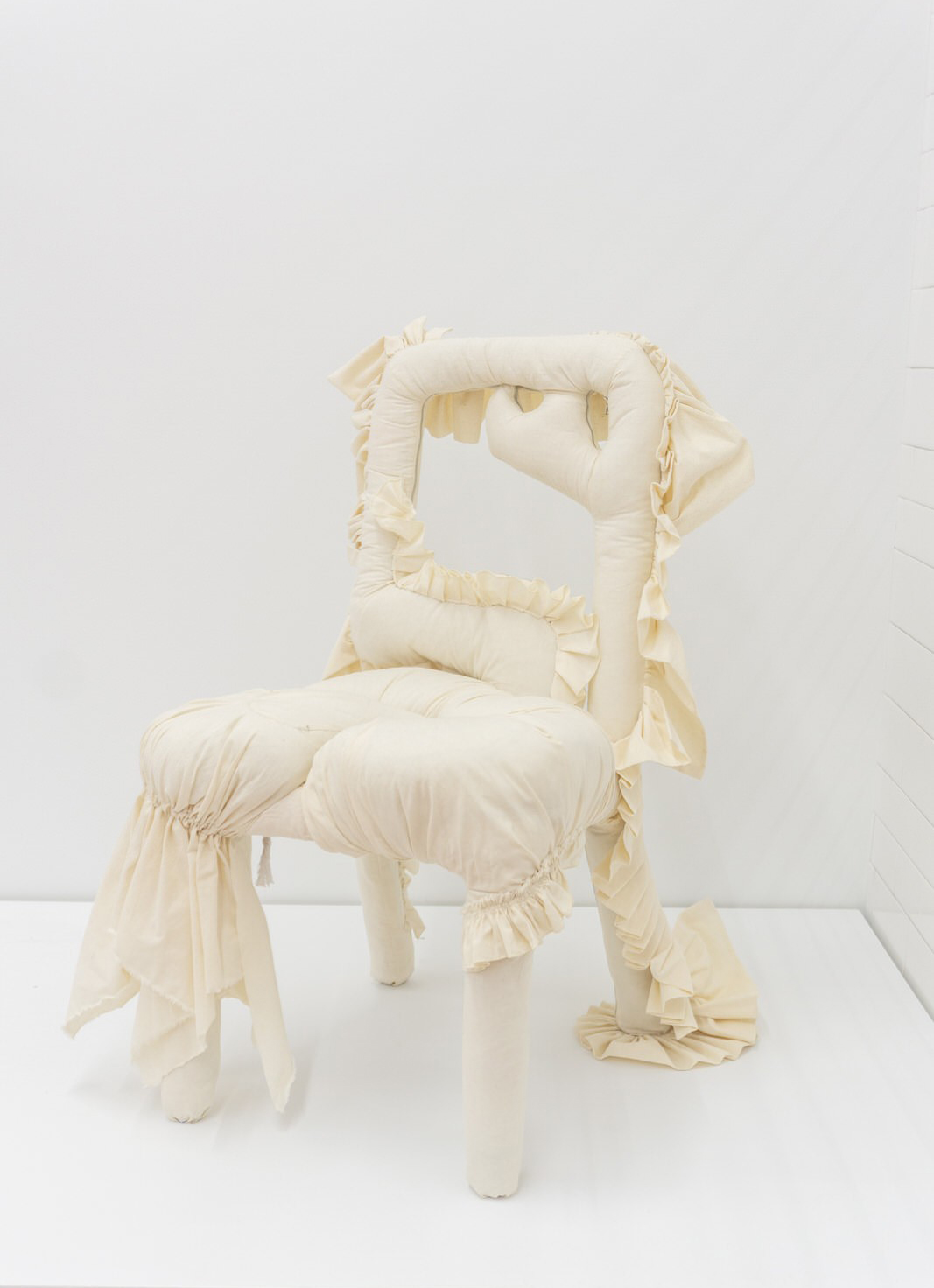 A white chair with ruffles on it.