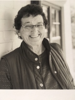 A black and white photo of an older woman smiling.