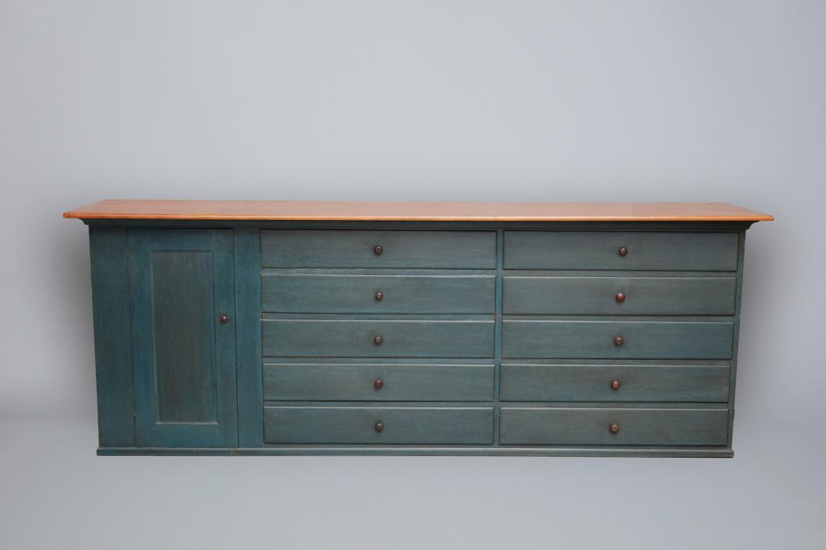 A blue and brown dresser with drawers.