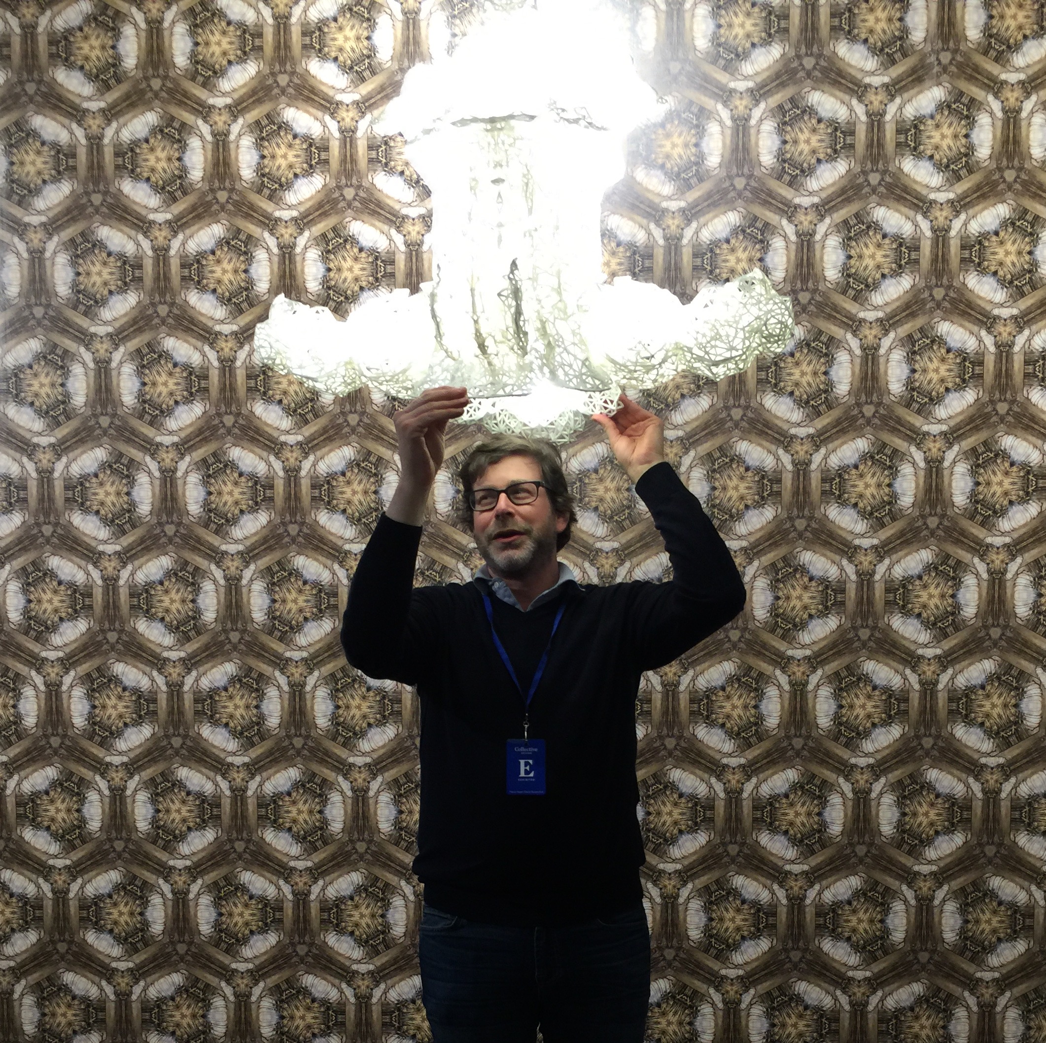 A man holding up a large glass chandelier.