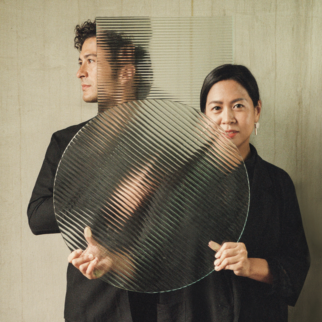 A man and a woman holding a glass plate.