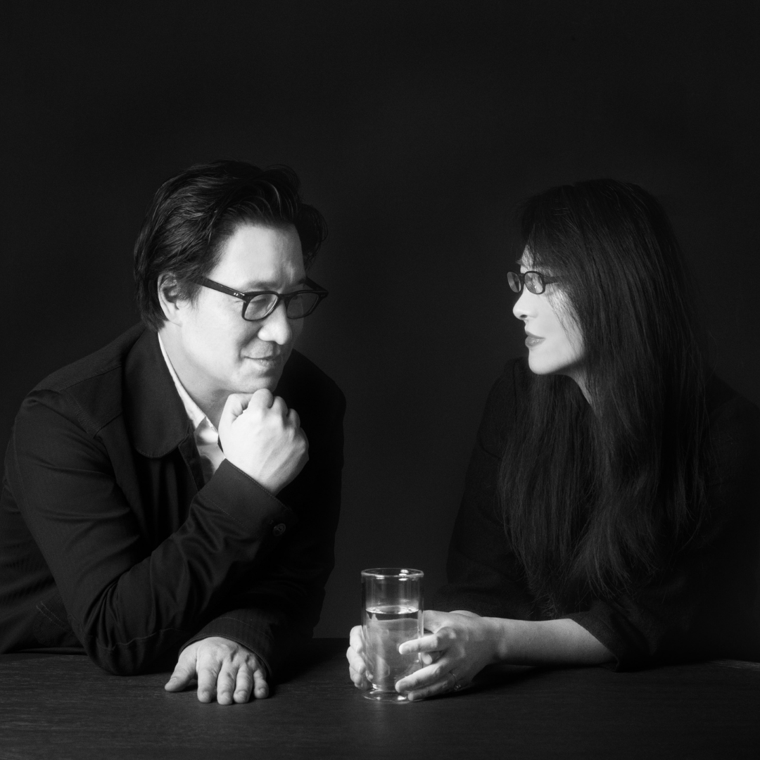 A black and white photo of a man and woman sitting at a table.