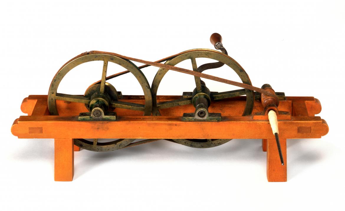 Two wooden wheels on a wooden stand.