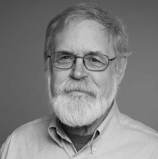 A black and white photo of an older man with a beard.