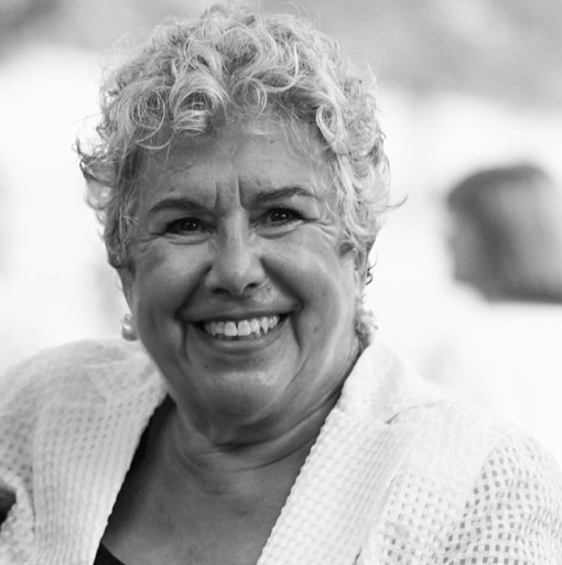 A black and white photo of an older woman smiling.