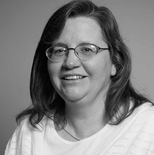 A black and white photo of a woman wearing glasses.