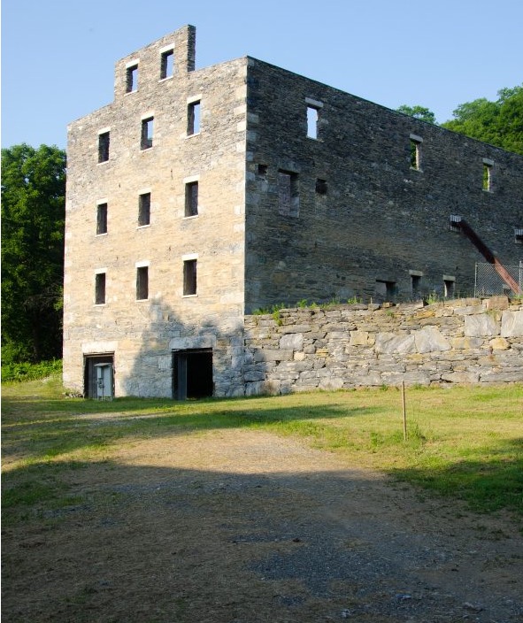 An old stone building in the middle of a field.