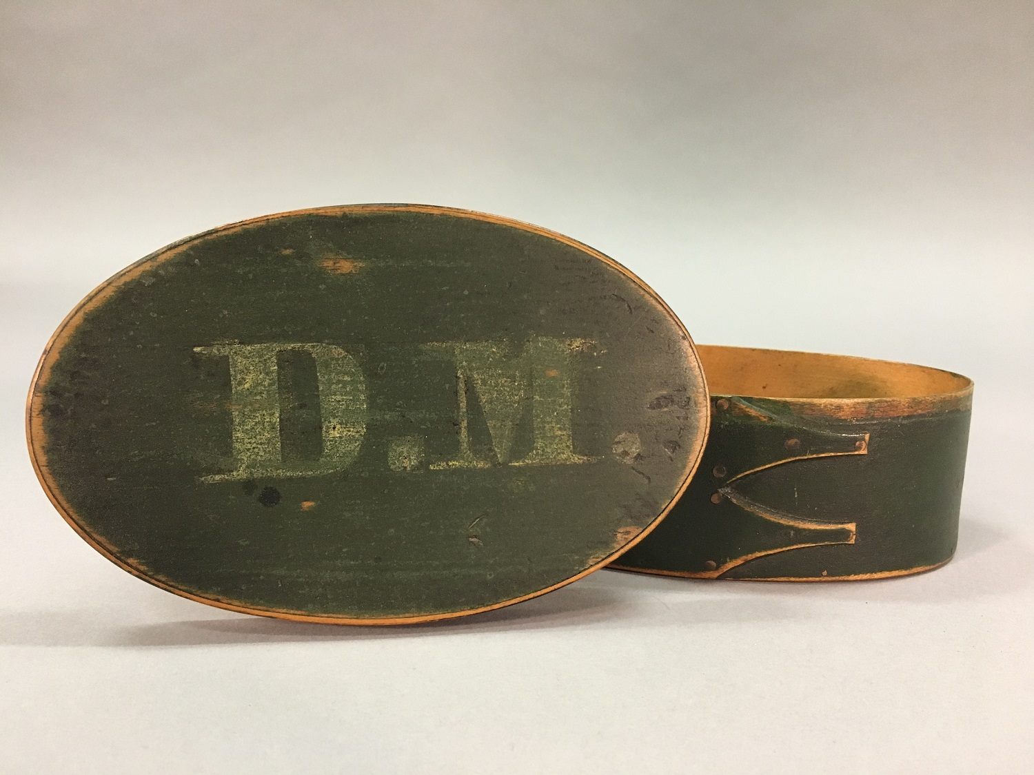 A green wooden box with the letter dm on it.