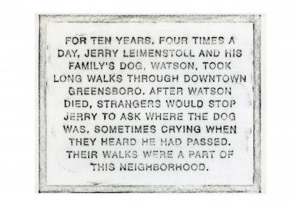 Plaque detailing the community impact of jerry leimenstoll's daily walks with his dog, watson, through downtown greensboro and the neighborhood's reaction to the dog's passing.