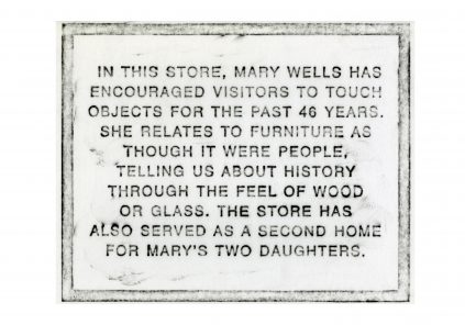 Informative plaque describing the tactile and personal approach to furniture sales and history in mary's store, which also doubles as a home for her daughters.