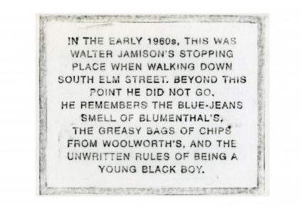 Plaque with a historical description from walter jamison about his experiences walking down south elm street in the early 1960s.